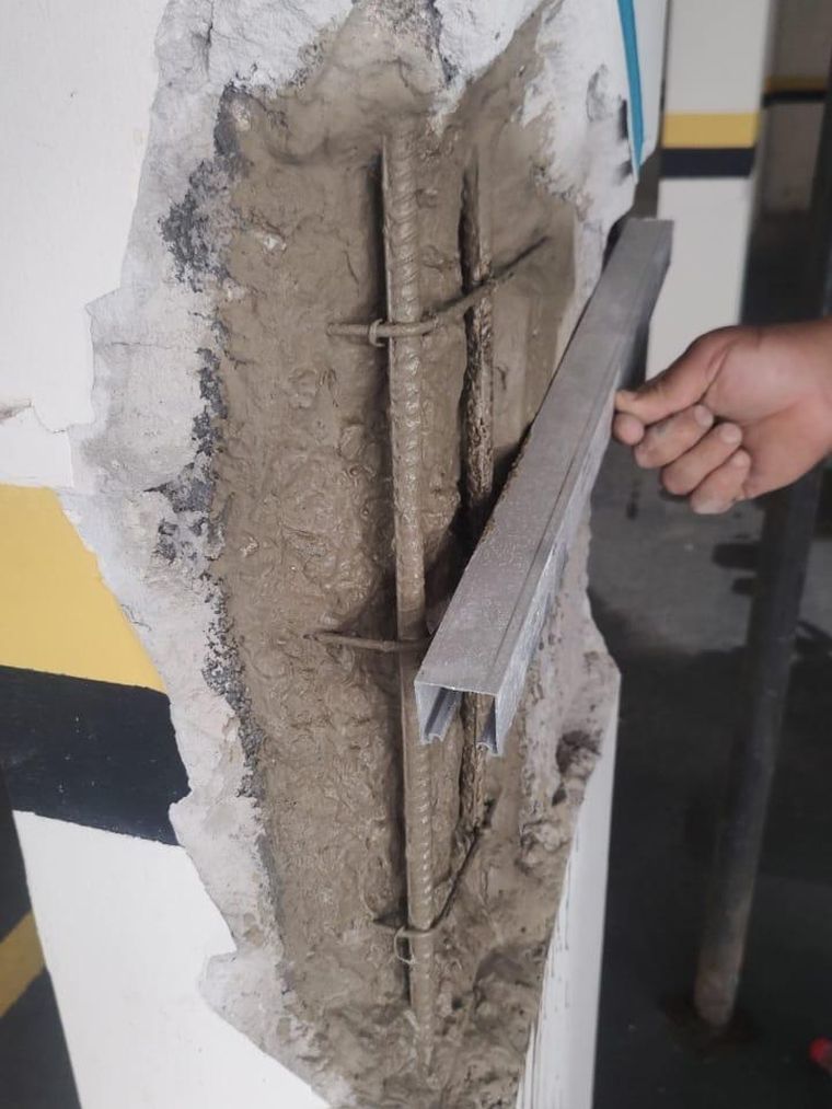 Armadura de pilar exposta e corroída, com o concreto aberto e medido durante vistoria técnica da HG Engenharia