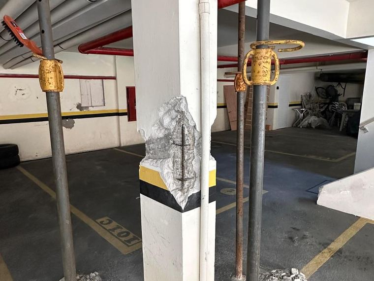 Escoramento metálico preventivo em garagem de condomínio durante reparo estrutural