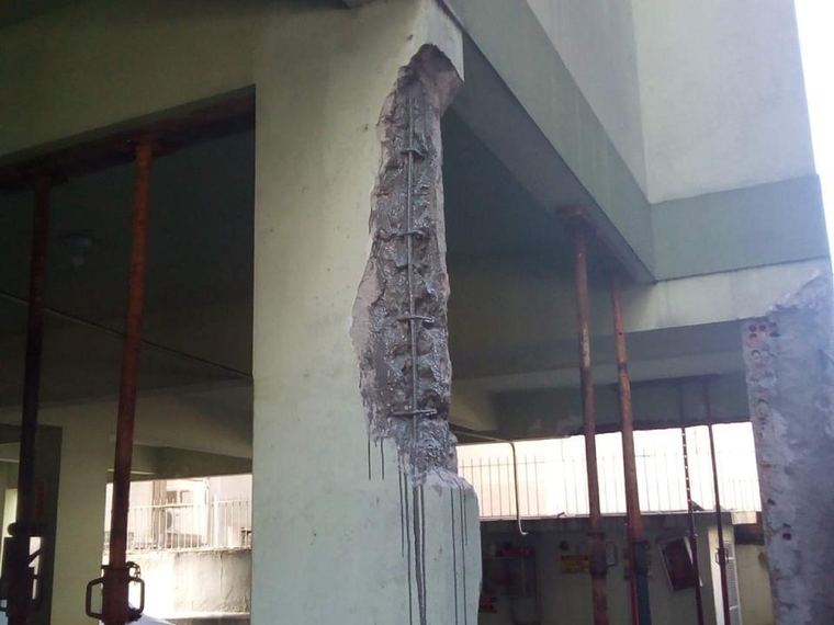 Pilar de edifício com o concreto degradado removido e escoramento metálico instalado