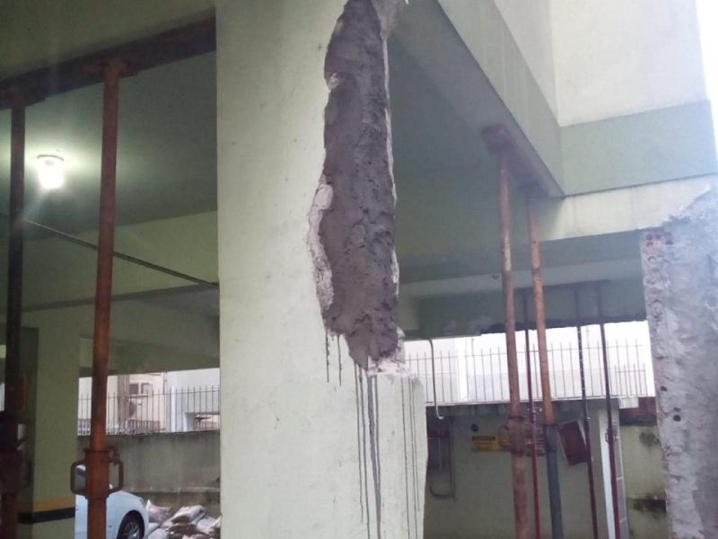 Pilar de garagem com concreto reconstituído e escoramento metálico durante recuperação estrutural em condomínio de Florianópolis - SC