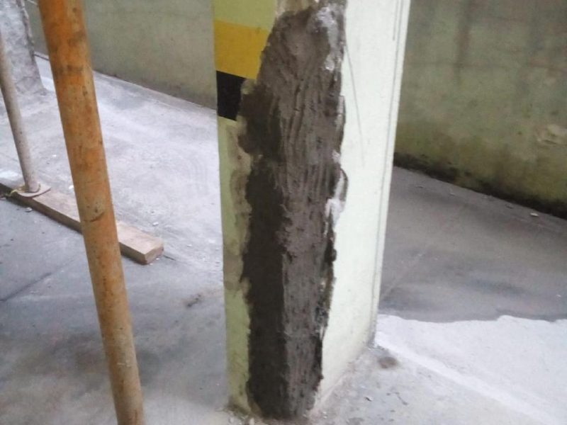 Pilar de concreto com reparo estrutural e escoramento durante recuperação de estrutura predial em Florianópolis - SC